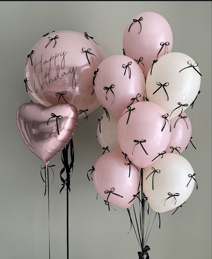 pink and white balloons with black writing on them