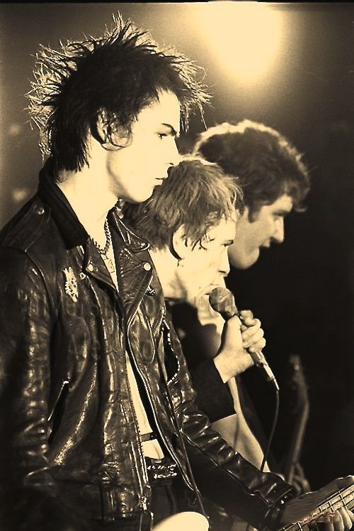 black and white photograph of young men singing into microphones