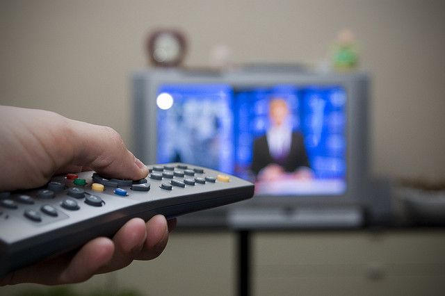 a hand holding a remote control in front of a television with the words watch all the tv you want without paying a cable bill