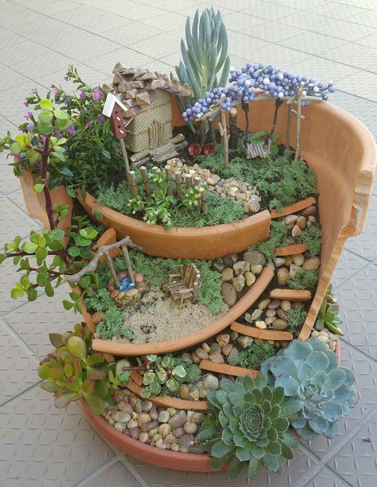 a potted planter with succulents, rocks and plants in it