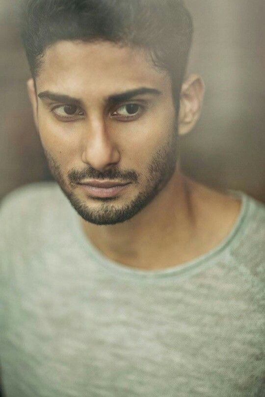 a close up of a person wearing a shirt and looking at the camera with a serious look on his face