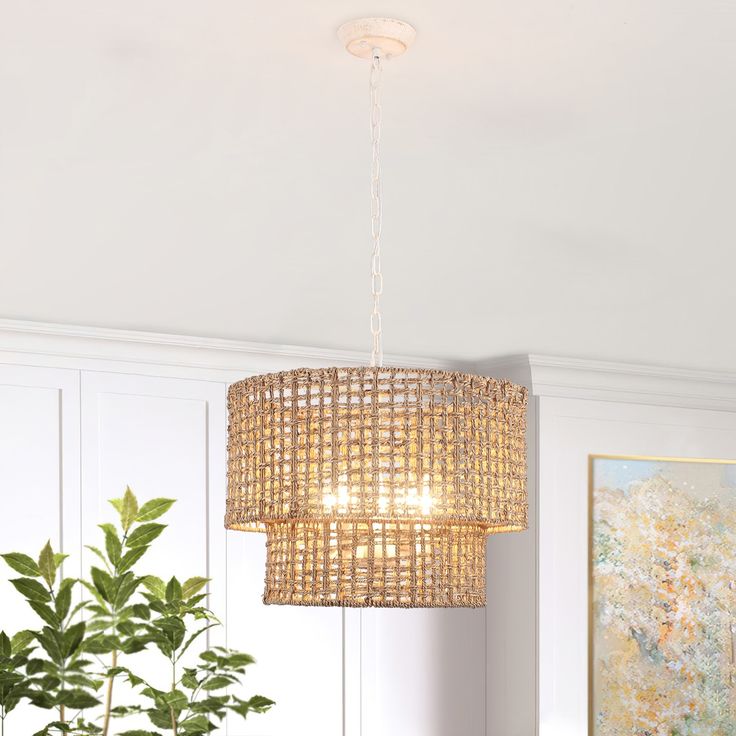 a chandelier hanging from the ceiling over a dining room table with chairs and a potted plant