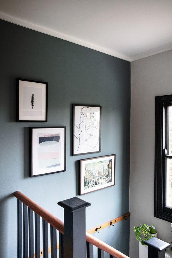 a room with pictures on the wall and stairs