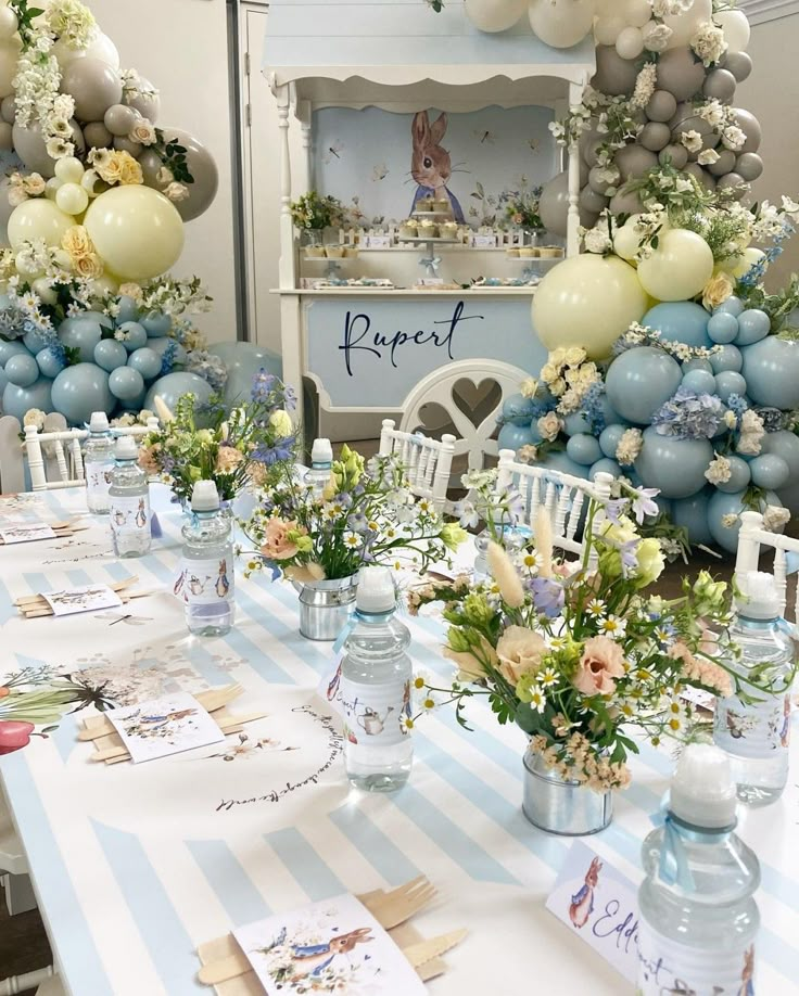 a table set up with balloons and flowers