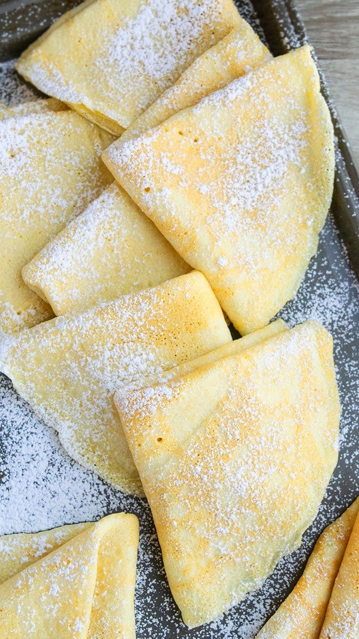 some pastries are sitting in a pan with powdered sugar on top