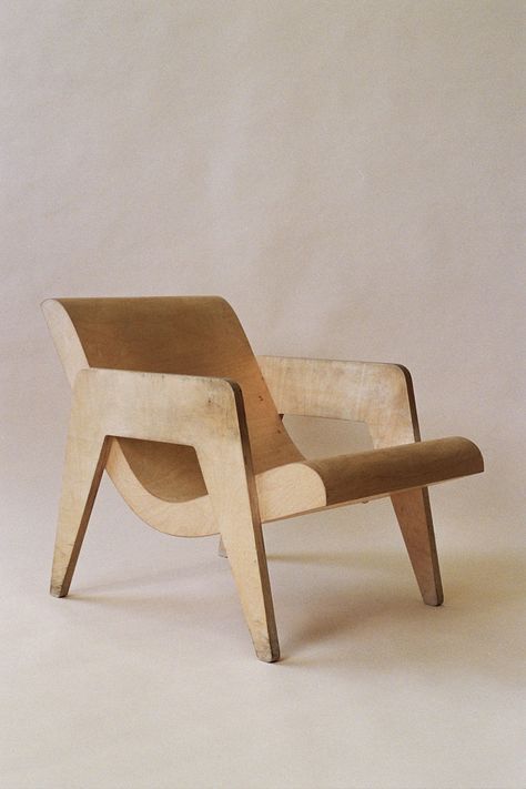 a wooden chair sitting on top of a white floor next to a brown object in front of a wall