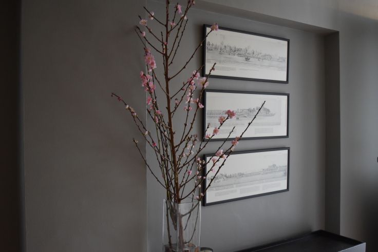 a vase filled with pink flowers next to two framed pictures