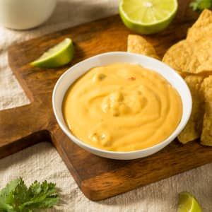 tortilla chips and guacamole dip on a cutting board