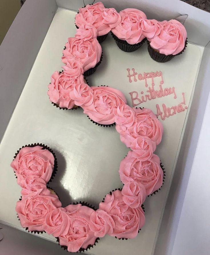 a birthday cake shaped like the number five with pink frosting and roses on it