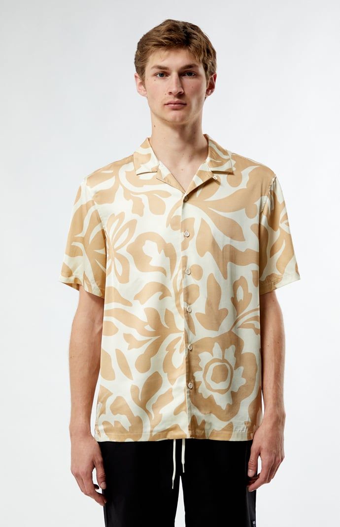 PacSun's Mari Tan Camp Shirt is a your go-to for laid-back sophistication. With its collared neckline, short sleeves, and regular fit, this shirt offers a timeless silhouette. Complete with button closures and a lightweight feel, its print throughout adds a touch of intrigue to your casual ensemble.


	Collared neckline
	Short sleeves
	Standard fit
	Button closures
	Custom pattern
	100% Rayon
	Machine washable
	Model is wearing size medium
	Model Measurements: 6'1.5” Height, 28” Waist, 32” Inseam Beige Johnny Collar Shirt With Relaxed Fit, Beige Short Sleeve Camp Shirt For Beach, Casual Beige Short Sleeve Shirt With Camp Collar, Beige Printed Shirt With Relaxed Fit, Casual Beige Camp Collar Shirt, Beige Camp Shirt For Spring Vacation, Beige Short Sleeve Camp Shirt For Spring, Relaxed Fit Beige Camp Shirt For Vacation, Classic Camp Shirt For Summer Beach