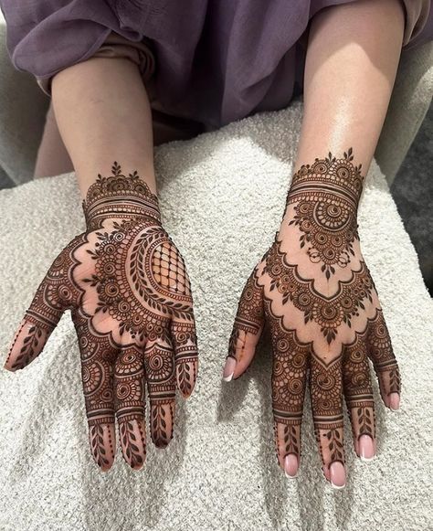 two hands with henna designs on them