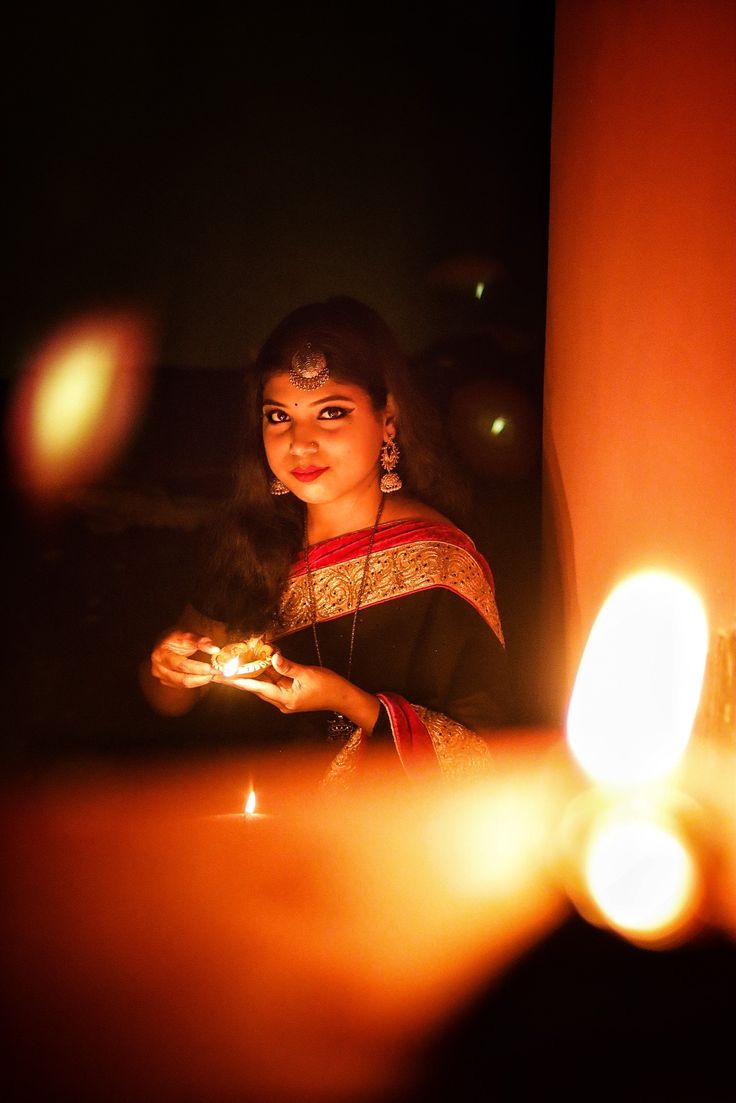 a woman holding a lit candle in her hand