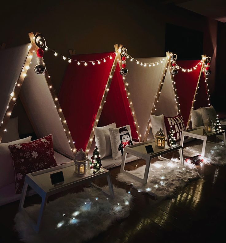 christmas lights are hanging from the ceiling in front of red and white tents with snowflakes on them