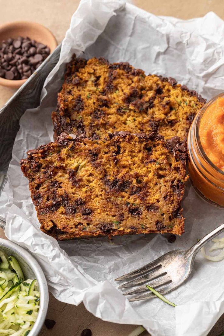 two pieces of bread sitting on top of a table next to a bowl of beans