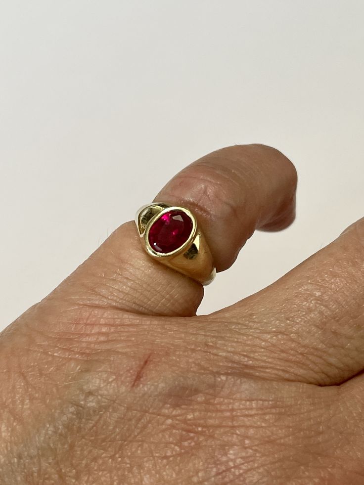 Amazing vintage 14k yellow gold created ruby ring, circa 1960s! The created red ruby weighs an estimated 1.21 carats, is oval cut, and is a stunning deep red. The setting contains a classic design with a high polish finish. Classic statement piece of fine retro jewelry showcasing a stunning created ruby, circa 1960s! ERA - Circa 1960s, Retro METAL / MATERIAL - 14k yellow gold, 1 created ruby (estimated 1.21 carats) [Synthetic ruby contains essentially the same chemical composition & properti Yellow Gold Ruby Signet Ring With Polished Finish, Vintage Ruby Rings With Polished Finish, Classic Gold Ruby Signet Ring, Classic Yellow Gold Ruby Signet Ring, Vintage Ruby Ring In 14k Gold With Oval Cabochon, Classic Yellow Gold Ruby Ring With Oval Cabochon, Classic Ruby Signet Ring, Classic 14k Gold Red Signet Ring, Classic Red 14k Gold Signet Ring