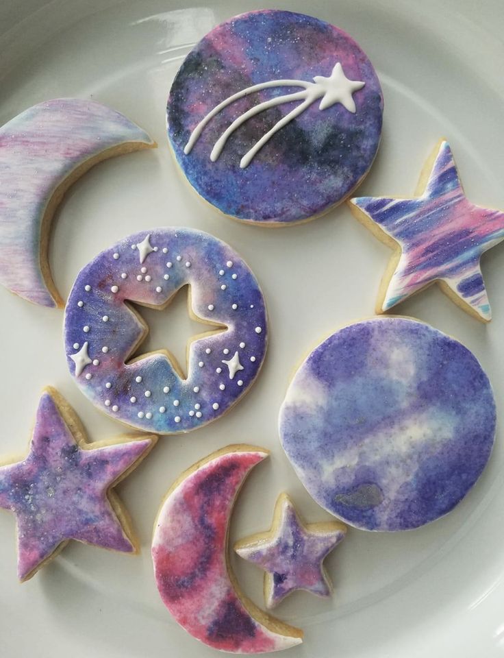 some decorated cookies on a plate with stars and crescents