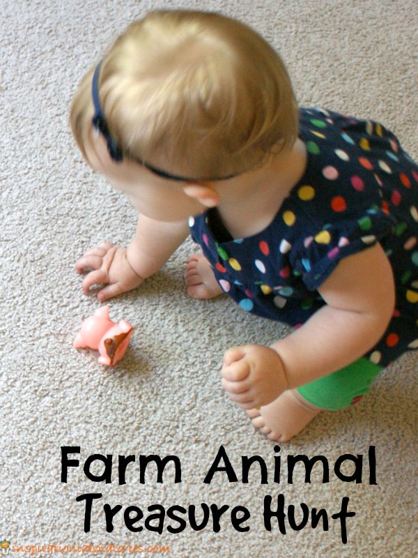 a toddler playing with a toy on the floor that says farm animal treasure hunt