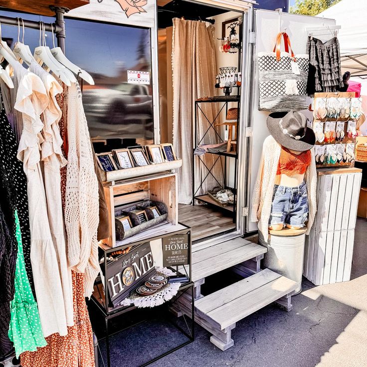 an outdoor clothing store with clothes hanging on the rack and other items in front of it