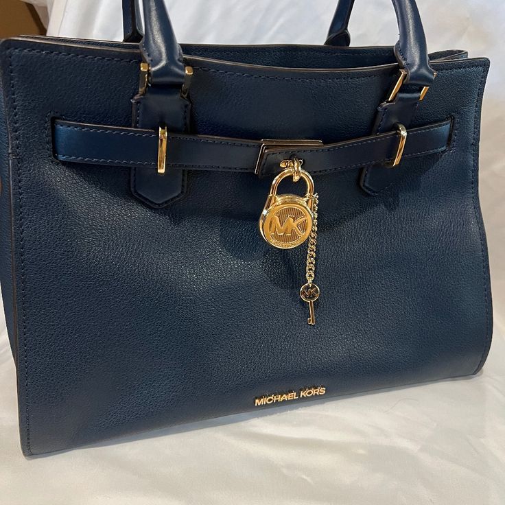 Beautiful Navy Bag With Gold Accents In Hardware Outside. Inside Is A Zippered Pocket On One Side And An Open Pocket On The Other. An Additional Adjustable Long Strap To Carry Over The Shoulder Comes With It. The Strap Clips On And Off Easily And Has The Gold Hardware. Bag Is 13” Across.Side To Side, Bottom Side Gusset Is 7”, Top To Bottom Or Depth Is 10”. The Gold Lock On Front Has A Key That Unlocks It And Can Release The Top Portion Of The Bag To Open Top Wider Creating A Box-Like Look. I Hav Blue Leather Bag With Lock, Blue Formal Bag With Turn-lock Closure, Blue Everyday Bag With Lock, Luxury Navy Bags With Gold-tone Hardware, Blue Travel Bag With Turn-lock Closure, Blue Bags With Lock For Formal Occasions, Blue Office Bag With Turn-lock Closure, Luxury Navy Shoulder Bag With Gold-tone Hardware, Luxury Blue Bag With Metal Hardware