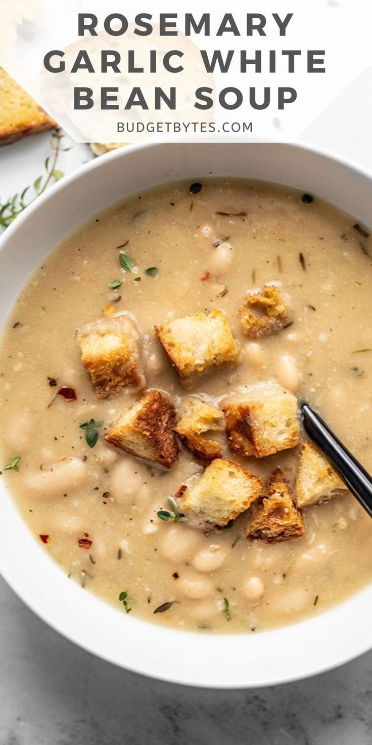 a white bowl filled with soup and croutons