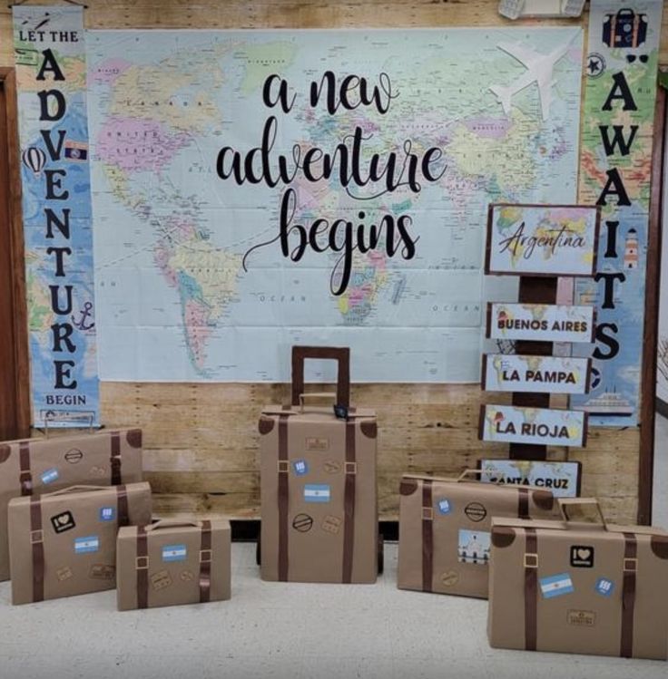 suitcases are lined up in front of a world map and words on the wall