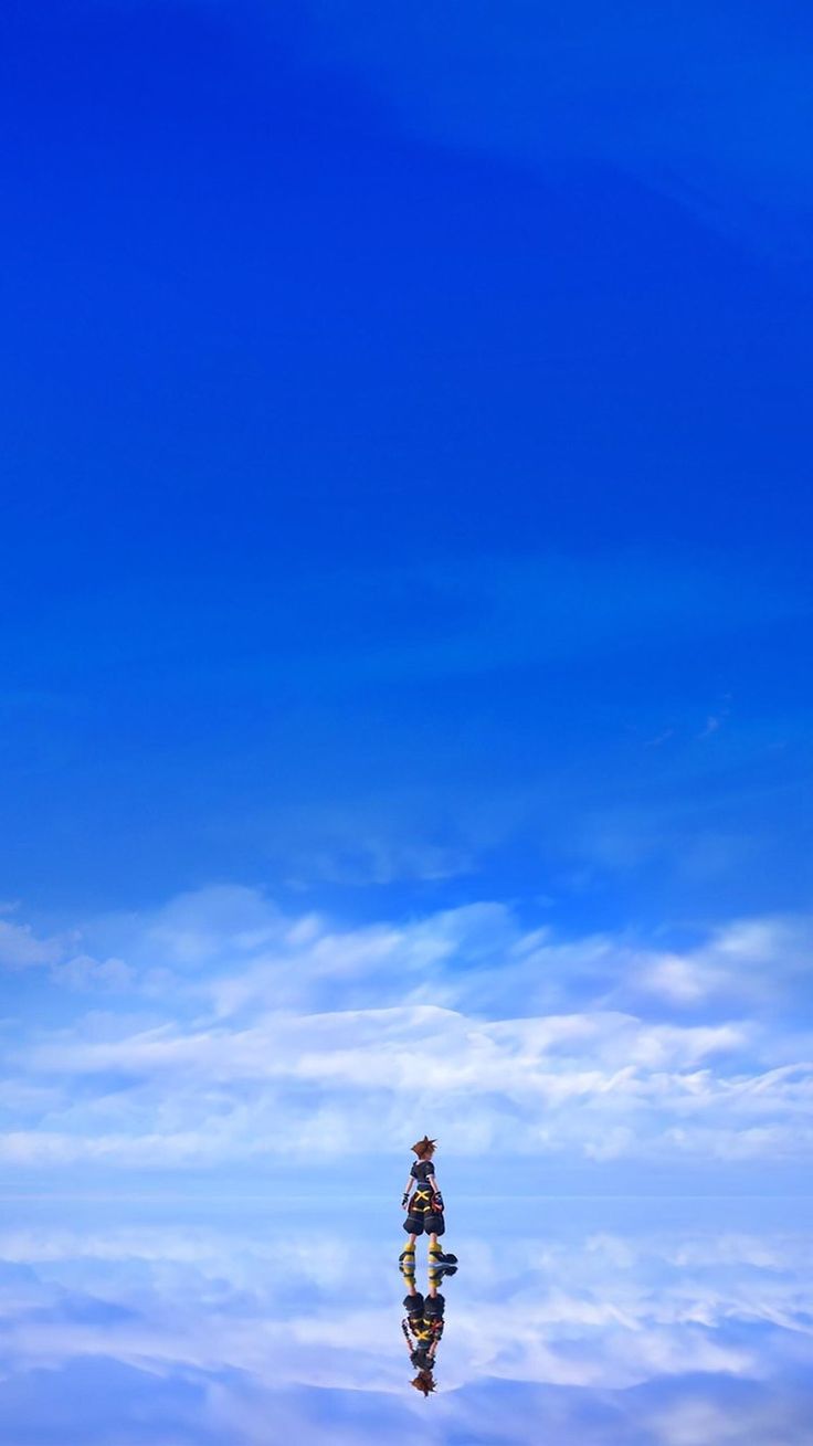 an airplane flying in the blue sky with clouds reflected on it's surface and its reflection in the water