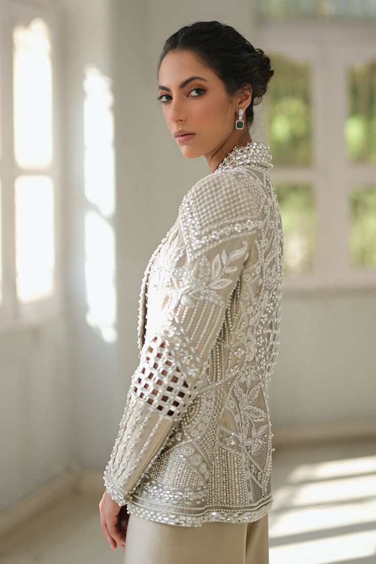 A slate coloured tissue jacket with folded lapels is rendered with intricate cutwork and thread and embroidery. Paired with ivory choli and slate-coloured charmeuse box trousers with embroidered hems; this outfit exudes sheer elegance. Model Height is 5'6 jacket length is 26" Indian Suit With Jacket, Co Ords Outfits Indian, Cut Work Embroidery, Western Men, Co Ords Outfits, Lace Suit, Outfits Indian, Suits Design, Embroidery Suits Design