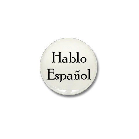 a white button with the words hablo espanol in black on it