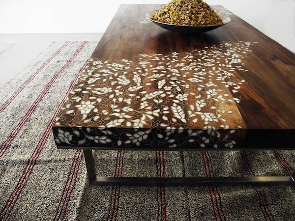 a table with a bowl of food on top of it next to a striped rug