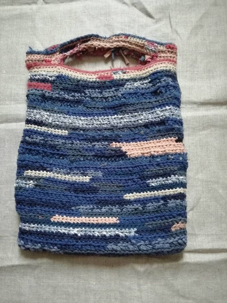 a crocheted bag sitting on top of a bed