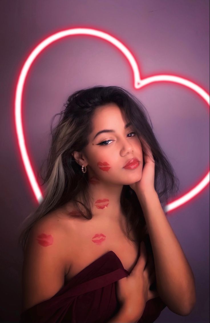 a woman with lipstick painted on her face in front of a heart shaped neon sign