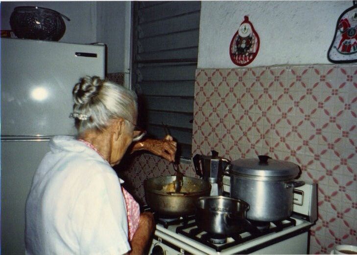 an old woman is cooking in the kitchen with pots and pans on the stove