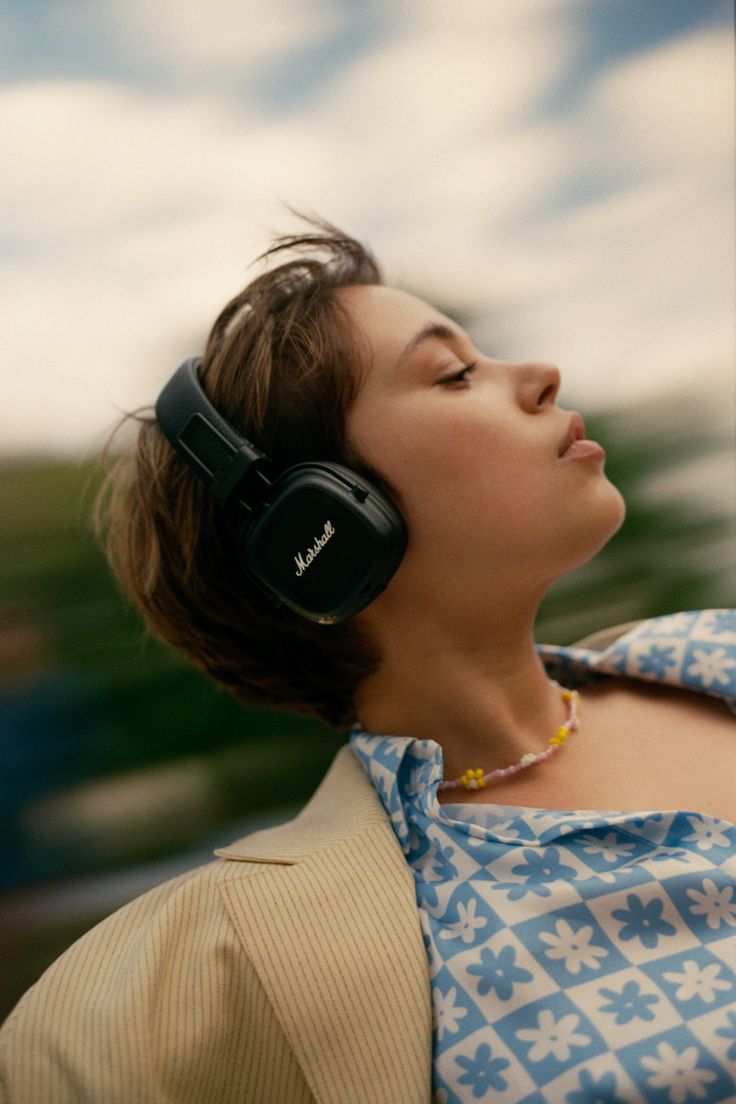 a woman wearing headphones looking up into the sky