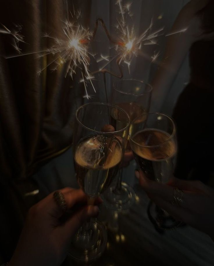 two people toasting with sparklers in their glasses