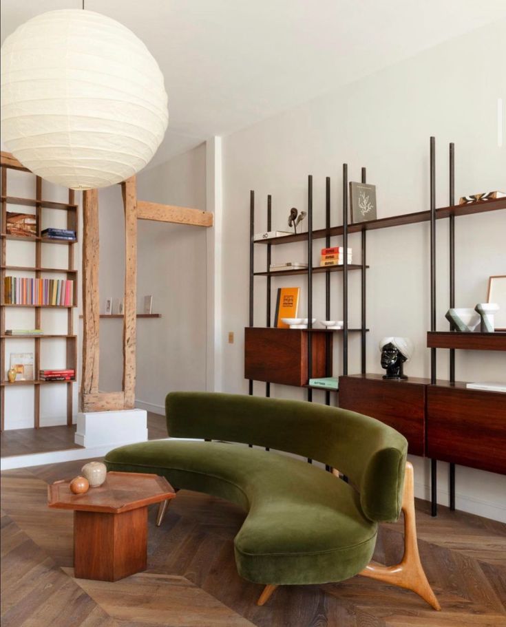 a living room filled with furniture and bookshelves next to a wooden coffee table