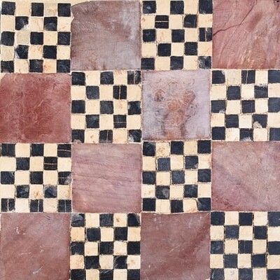 a black and white checkerboard pattern on a tile floor with red, brown, and tan colors