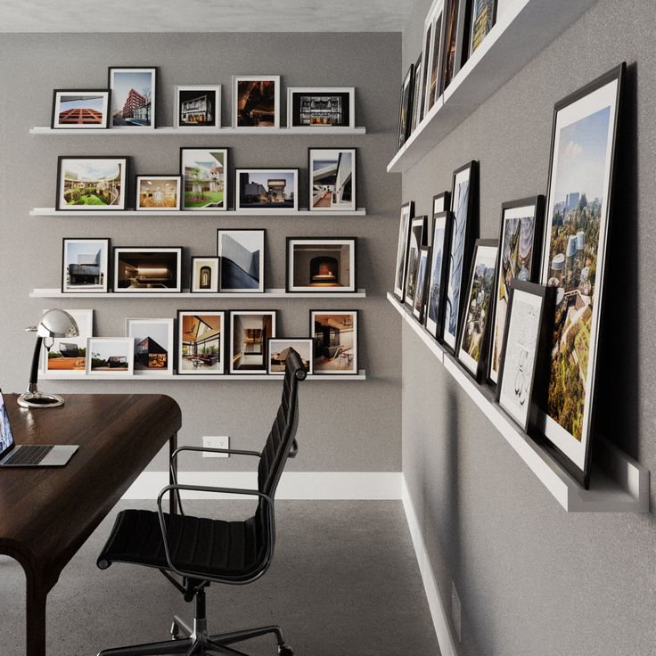 an office with many pictures on the wall and a desk in front of it,