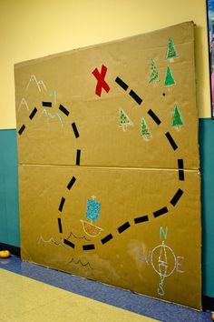 a cardboard board with some drawings on it in the hallway next to a wall that has been painted yellow and blue