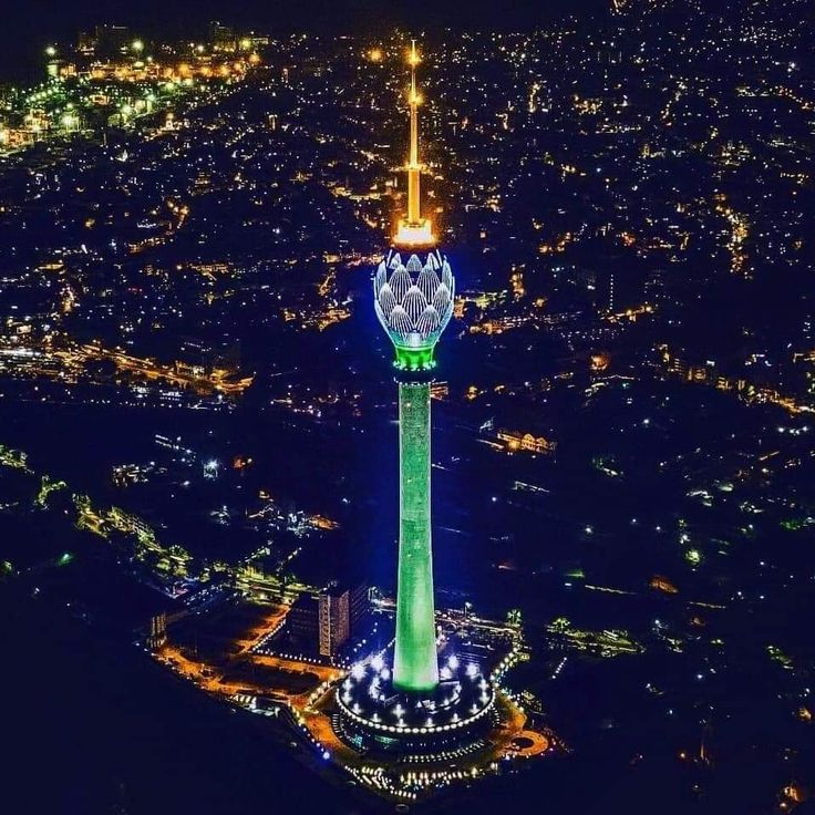 an aerial view of a city at night with the lights on and buildings lit up