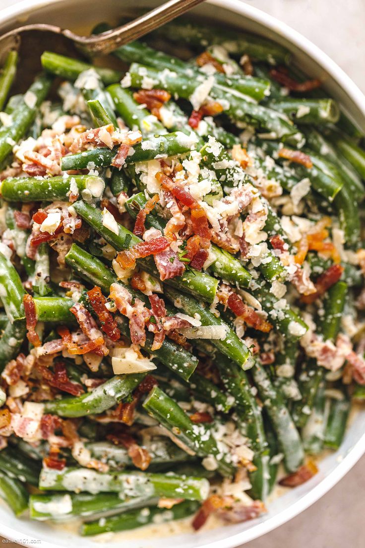 a white bowl filled with green beans and bacon