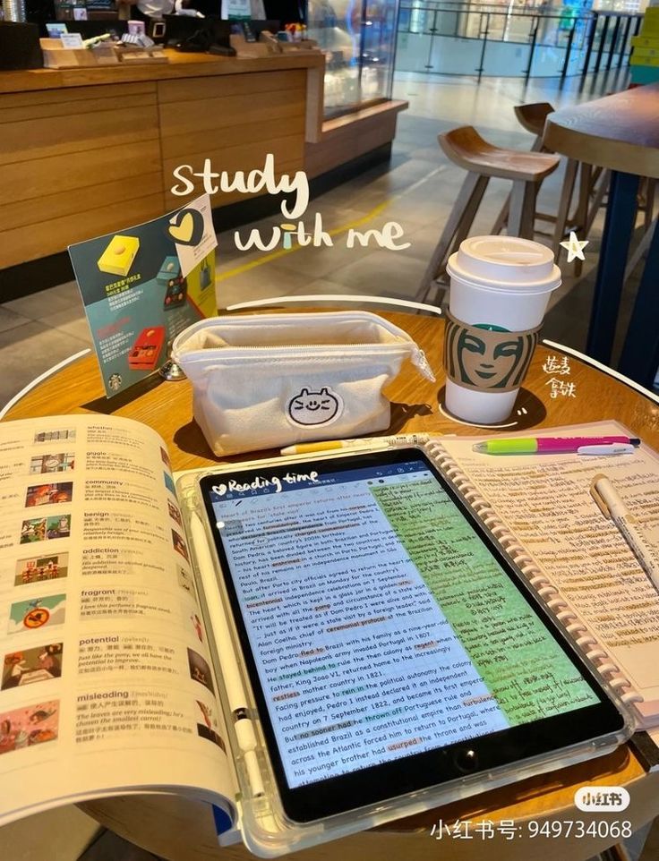 an open book sitting on top of a table next to a tablet