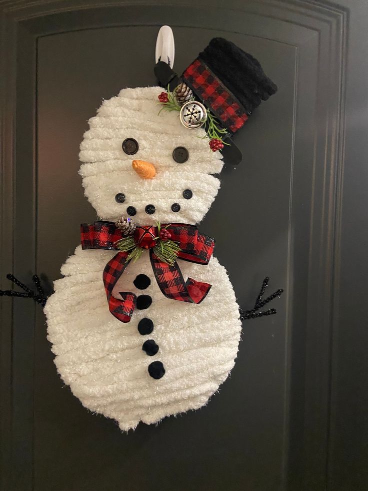 a snowman made out of toilet paper on the front door