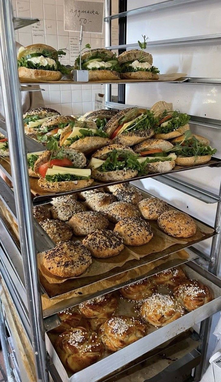 a display case filled with lots of different types of sandwiches and pastries on trays