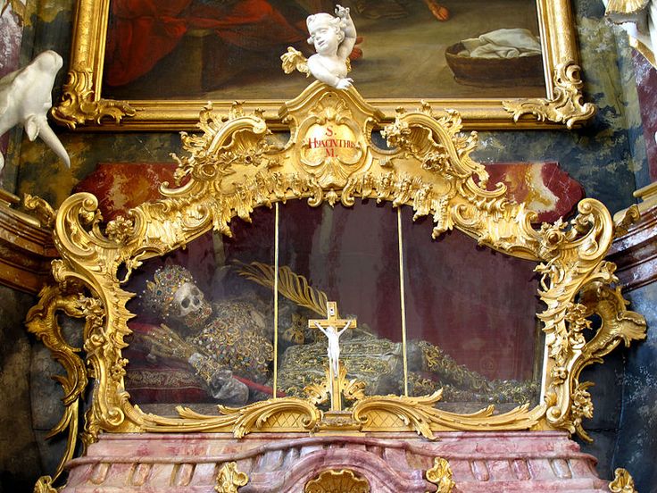 an ornately decorated wall with paintings and sculptures on the sides, including a crucifix