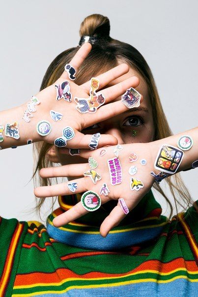 a girl with her hands covered in stickers