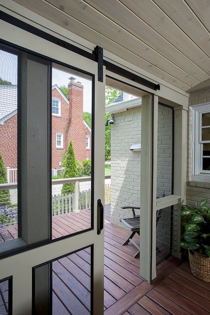 an open door to a porch with a basket full of plants on the other side