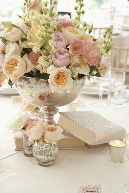 a vase filled with flowers sitting on top of a table next to an open book