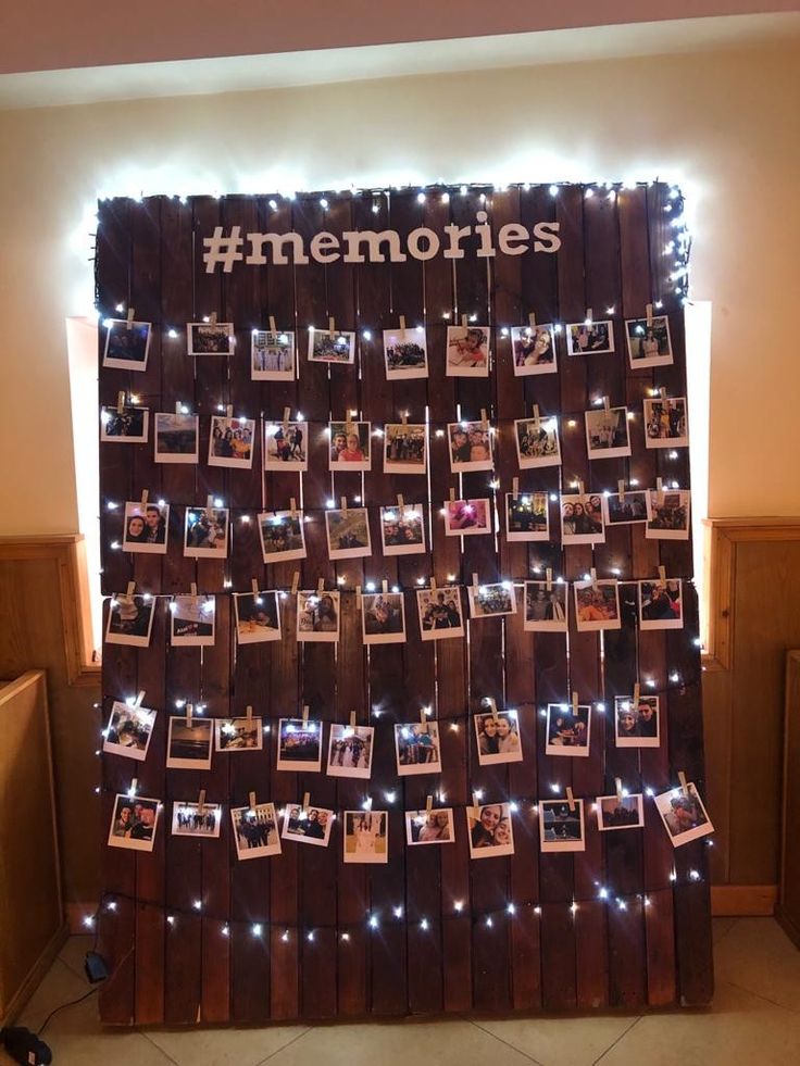 a wooden wall with pictures on it and lights around the edges that spell out memories