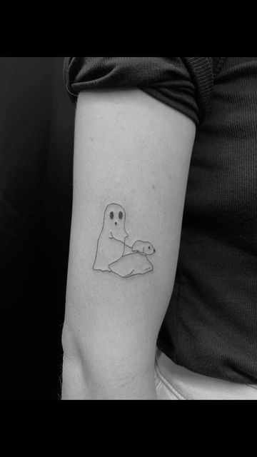 a person with a small ghost tattoo on their arm