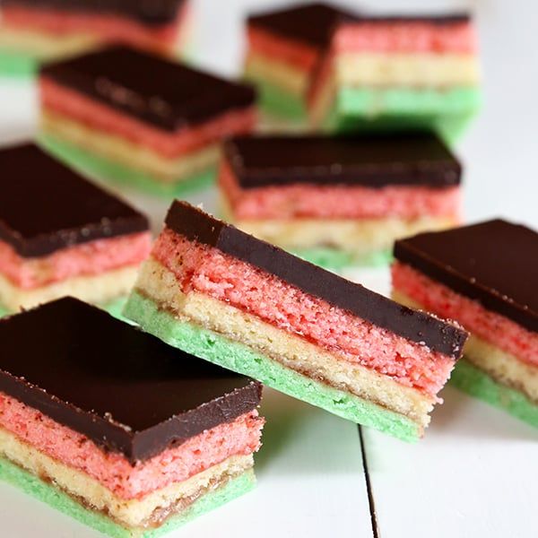 several pieces of cake sitting on top of each other with chocolate and colored frosting